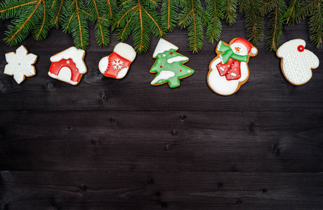 圣诞节背景边界与美味的自制姜饼饼干和杉树枝在木桌上，俯视平躺。 圣诞树雪花屋圣诞老人袜子复制空间