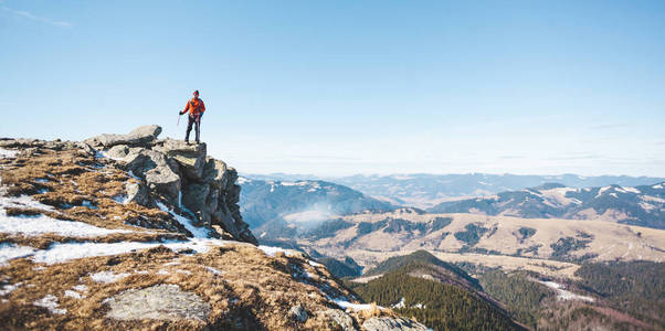 在阳光明媚的日子里，登山者带着背包在上面。 一个人上了山，人们穿过美丽的荒野，爬上了山顶，享受着他的成功。