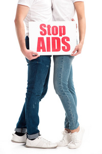 异性情侣拥抱和持卡的剪短图像，并在白色上隔离艾滋病文本