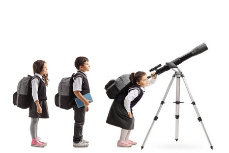 排队等着看的学童通过一个隔离在白色背景上的望远镜