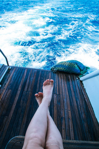 s legs overlooking the waves after the yacht. Stop on the ship. 