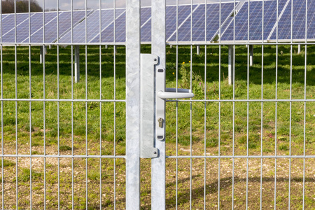 在德国南部农村的一个阳光明媚的秋天，在阵列场光伏区前的栅栏上安装了安装在铝架上的面板