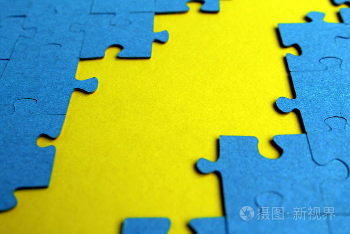 蓝色拼图散落在黄色背景上