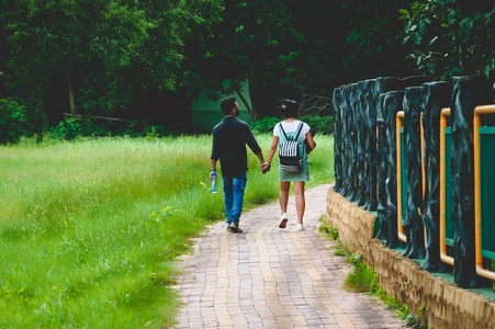 在浪漫的夏日，两对快乐的年轻情侣在绿色的秋天公园散步。 婚前婚姻订婚的概念。 团结的组成。 印度加尔各答植物园