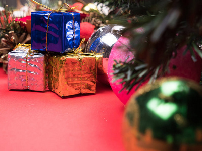 圣诞节礼物盒包装在不同颜色的圣诞树下的红色背景