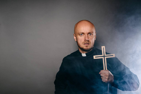 受惊受怕的驱魔天主教牧师穿着黑色衬衫和白领照片