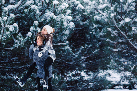 母亲和女儿玩在冬季森林乐趣