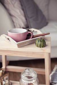 格子一杯热茶，秋天装饰一本书，一把南瓜放在木椅上。 舒适的秋天装饰。 秋季内部沙发。 跌倒。 冬天。