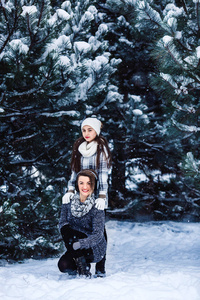 母亲和女儿玩在冬季森林乐趣