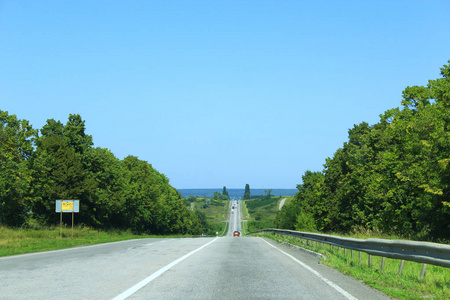 公路很远。 高速公路。 沥青路，有分隔带，两侧有树木和灌木丛。 旅行目的地之旅。 旅游概念