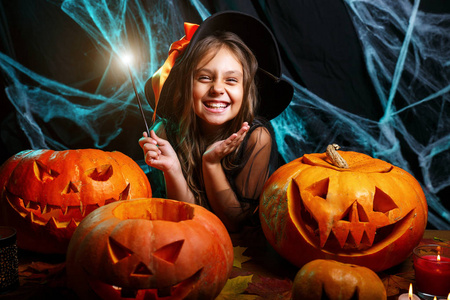 女巫魔杖万圣节女巫概念小女巫孩子喜欢玩魔杖在蜘蛛网和弯曲的南瓜
