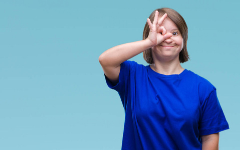年轻的成年妇女患有唐氏综合症，在孤立的背景下做OK手势，用手微笑的眼睛看着手指，用快乐的脸。