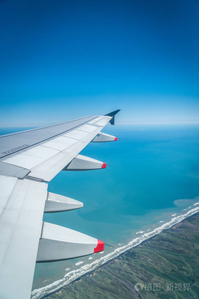 从飞机窗口观看，机翼飞越海岸线和海洋西海岸新西兰北岛