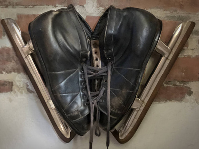 s ice skates hovering on a brick wall.