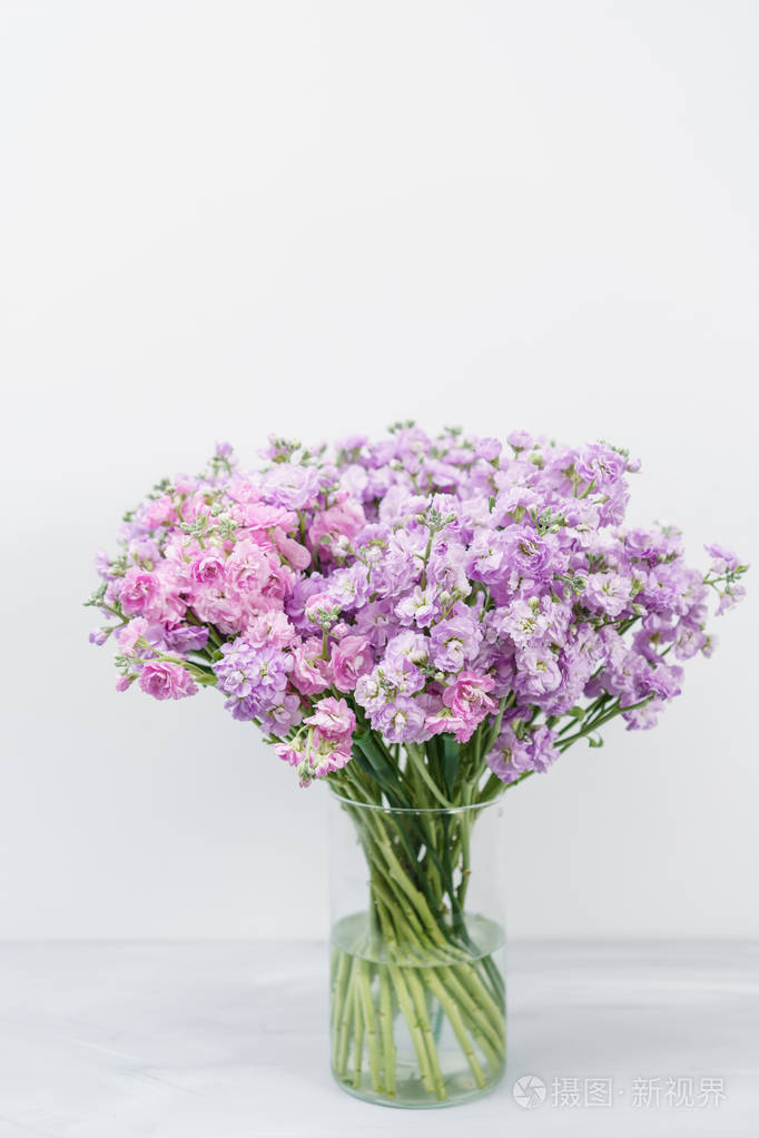 美丽的丁香花颜色紫罗兰levkoy或紫罗兰花束春天的花朵在花瓶的木桌上