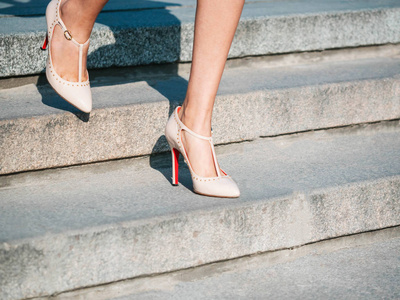 德沃里希性感的腿与米色高跟鞋爬上城市的楼梯.