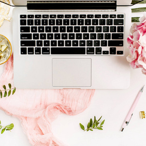 女性家庭办公桌与笔记本电脑，粉红色绣球花束，粉彩毯，怪物，叶子板和配件在白色背景。 平躺顶部视图玫瑰黄金工作区。