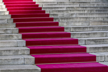 红地毯入口楼梯上的长红地毯. 成功的概念. 胜利.