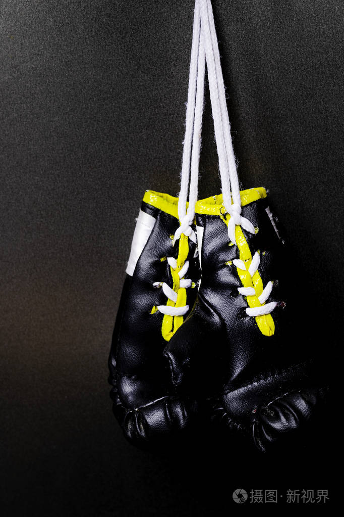 专业的黑色拳击手套挂在黑色背景和复制空间