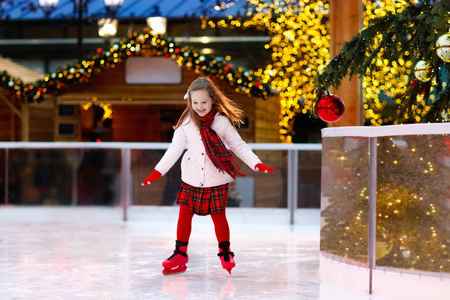 孩子们在冬季公园溜冰场滑冰.孩子们在圣诞集市上溜冰.
