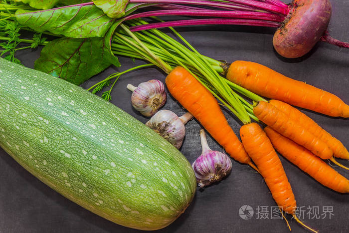花园新鲜蔬菜的分配。西葫芦，胡萝卜，大蒜和甜菜在桌子上。秋收。