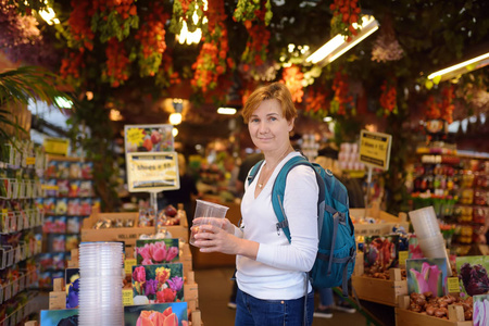 著名的阿姆斯特丹花卉市场布卢门马克。成熟的女人选择郁金香。园艺。