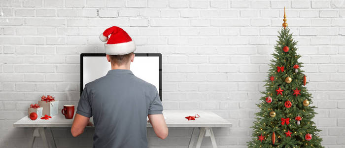 圣诞节假期网上购物。坐在办公桌前，在网上网上为朋友和家人买礼物。