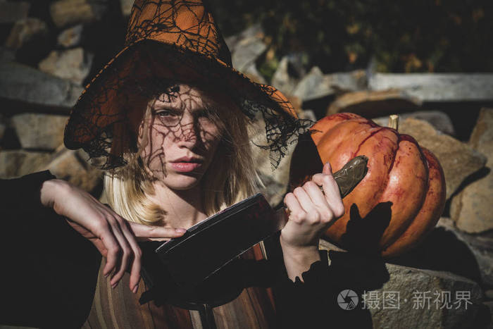 愉快的哥特式年轻女子在巫婆万圣节服装.万圣节概念