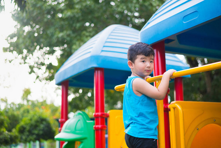 亚洲孩子在阳光下在操场玩耍，夏天快乐的孩子在幼儿园或学龄前学校院子里。