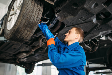 带灯的机械师检查汽车制动软管修理站。 轮胎服务车辆维修