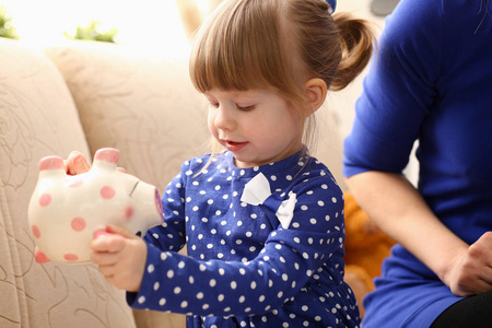 孩子小女孩胳膊投入硬币入 piggybank