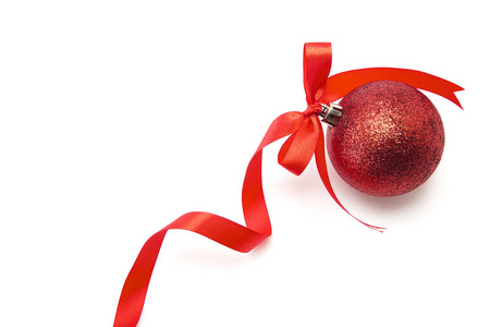 单个红色圣诞球与丝带弓白色背景简单的视觉布局与空间的设计。