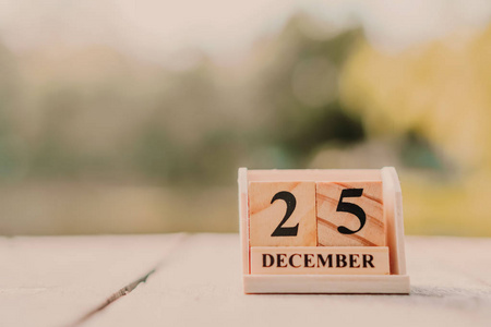 木砖块显示日期和月份日历12月25日或圣诞节。 庆祝和假日长周末季节的概念。