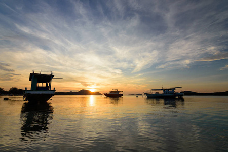 黄昏晨光与剪影船在拉赖海滩普吉岛。