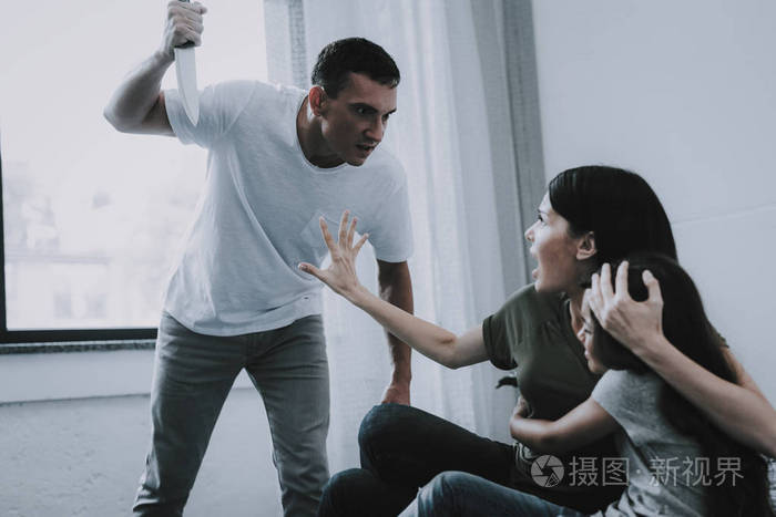 父亲尖叫的女人谁拥抱害怕的女儿躺在灰色的床上