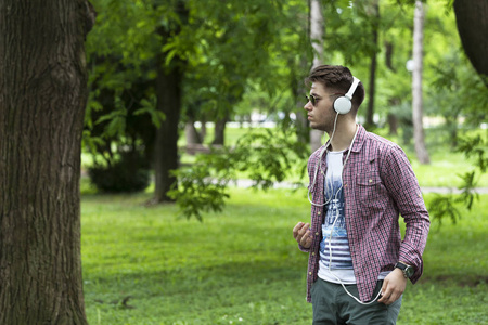 一个年轻人在手机上听音乐，有选择性的聚焦和小的景深。