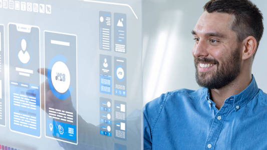 在未来的办公室创意设计师作品上的透明电脑显示器。 屏幕显示交互式移动用户界面的原型。