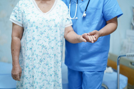 亚洲护士理疗师医生护理,帮助和支持老年或老年妇女患者下床在医院