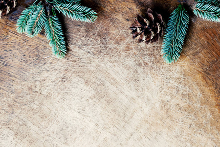 圣诞节背景与杉树枝和松果在乡村木板，空间为文字。时髦的圣诞壁纸。平躺，俯视。