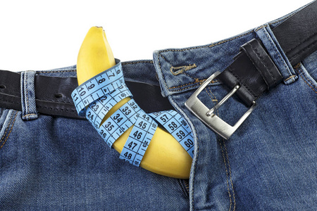 蓝色牛仔裤，带有测量带，白色背景上有黄色香蕉。男性牛仔裤与香蕉模仿男性生殖器。