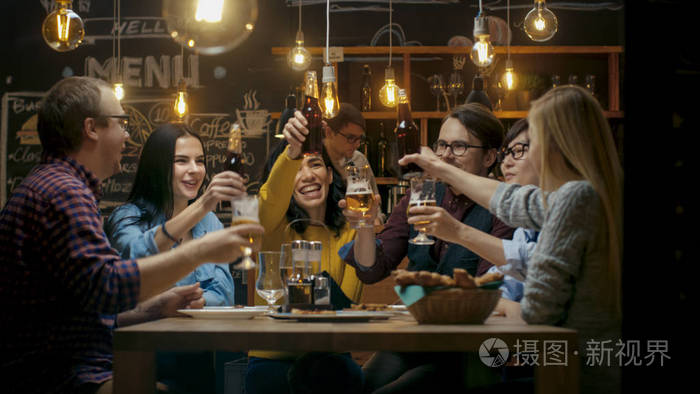 美丽的年轻人在时尚的酒吧/餐馆里玩得很开心.