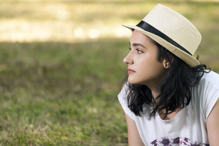 一个年轻女孩的肖像，有一张美丽的脸和一顶帽子在大自然中。 她很担心，等着别人。你的短信空间空了