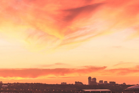 大都市在秋天美丽日落的背景下。 颜色是橙色粉红色和红色。