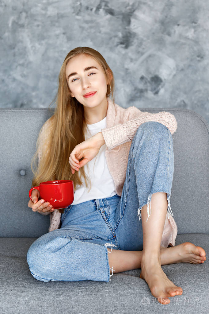 有吸引力的苗条女性在家庭情况下休息在沙发上在她的崇高公寓.