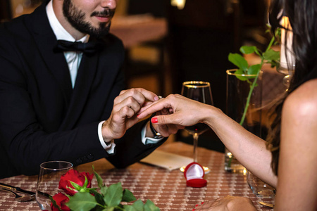 在餐厅的浪漫晚餐中，一个带订婚戒指的令人惊讶的男人