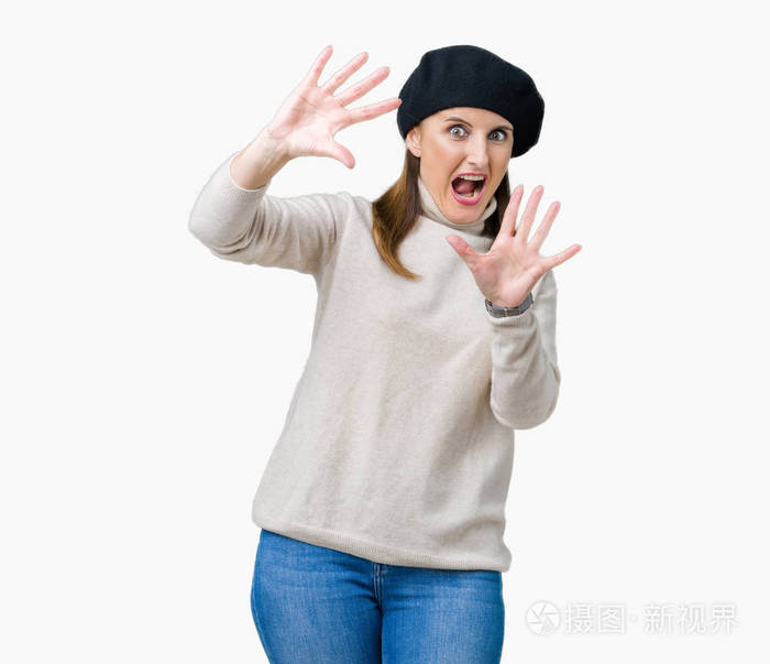 中年成熟的女人穿着冬天的毛衣,在孤立的背景上害怕和恐惧,表情停止