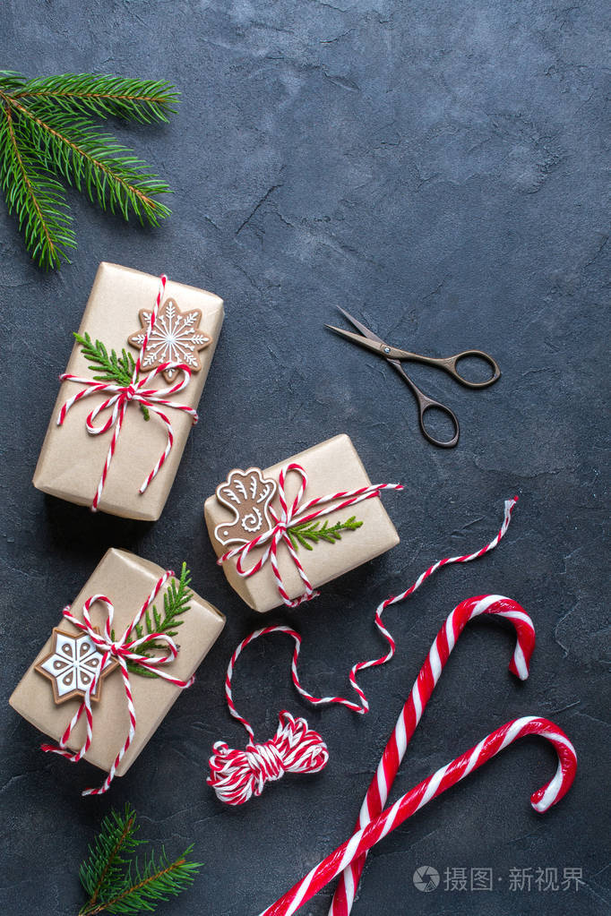 包装圣诞礼物. 黑暗桌子上的圣诞礼品盒和装饰品松枝.