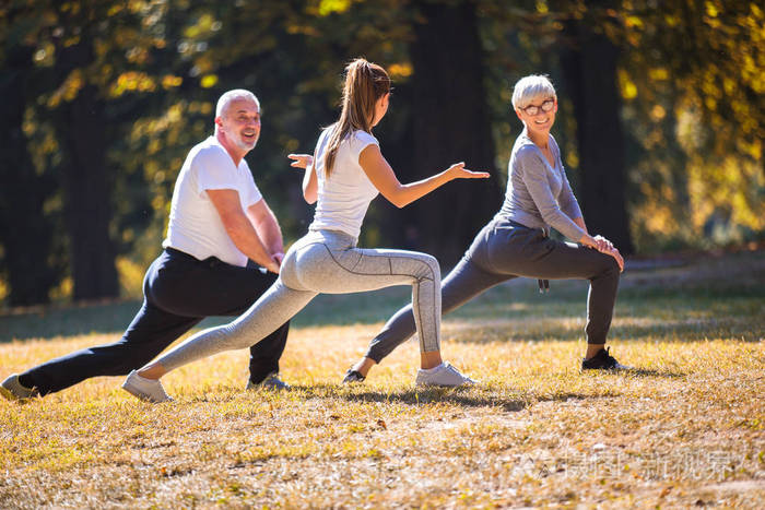 高级男女和年轻的女教练在新鲜空气中锻炼.