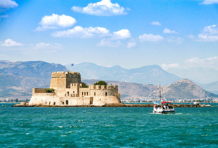 小木船把一群游客转移到布尔奇岛一座古老的监狱。 希腊。