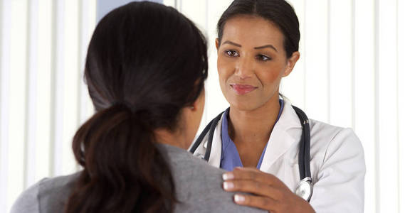 接近非裔美国医生与女性病人交谈